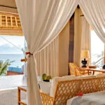 Putri Kasambi Villa featuring an elegant bedroom with ocean views, blending tropical luxury and serene comfort.